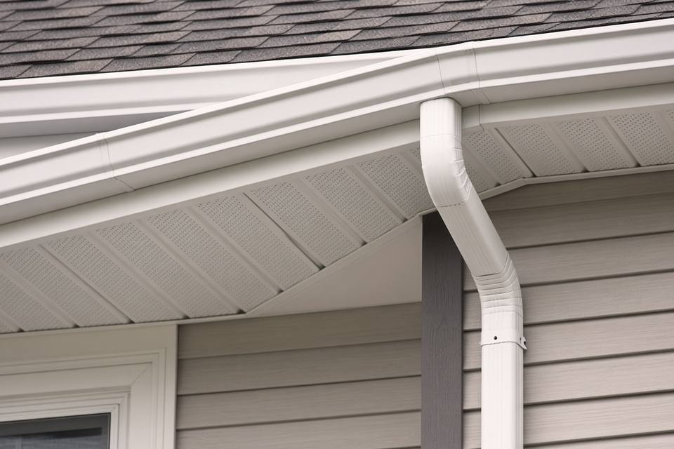 White gutter, downspout, and vented soffit under a shingle roof